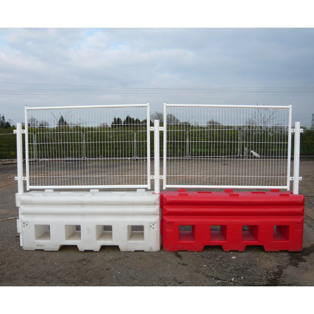 Two RB22 water-filled barriers, white and red, fitted with mesh top panels and joined in a continuous line on site