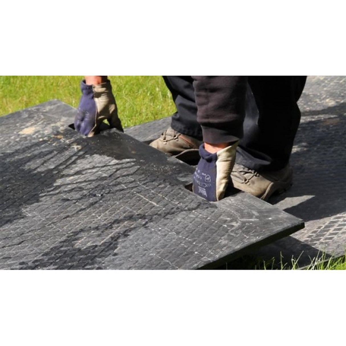 Two installers lifting a EuroTrak access mat into place using the hand holes