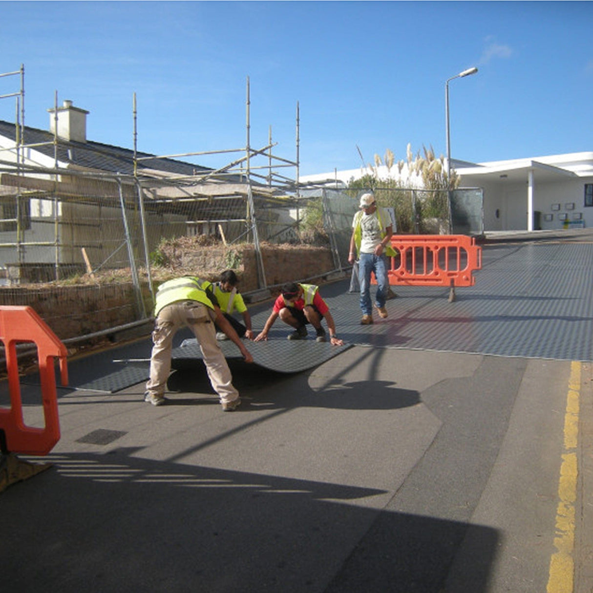DuraMatt ground protection mat being positioned on site by two installers