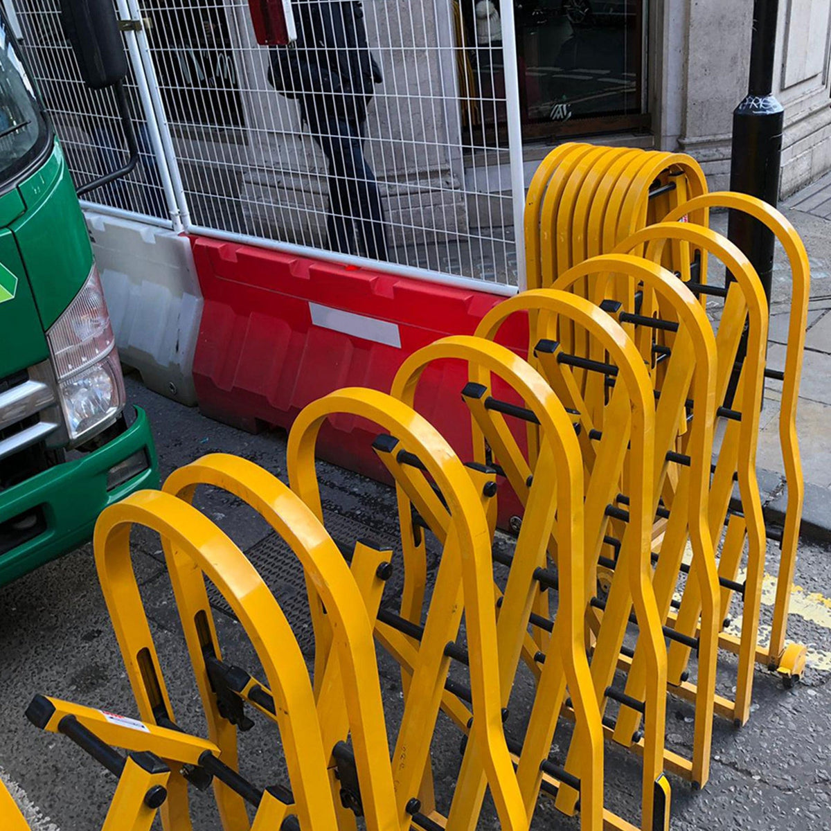 Yellow diamond concertina safety barrier on wheels for traffic control