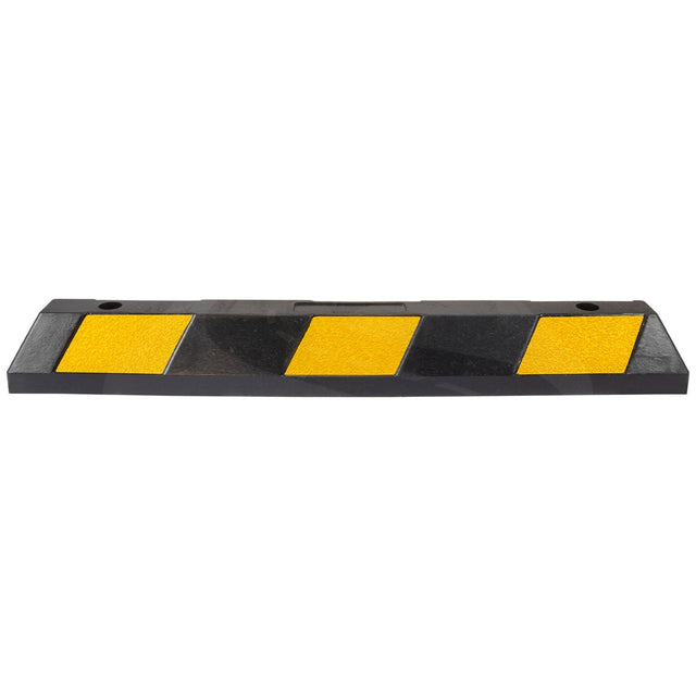 Close-up of a black rubber wheel stop block with reflective yellow chevron stripes