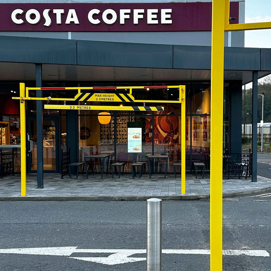 Yellow height restriction barrier fitted at a drive-thru entrance